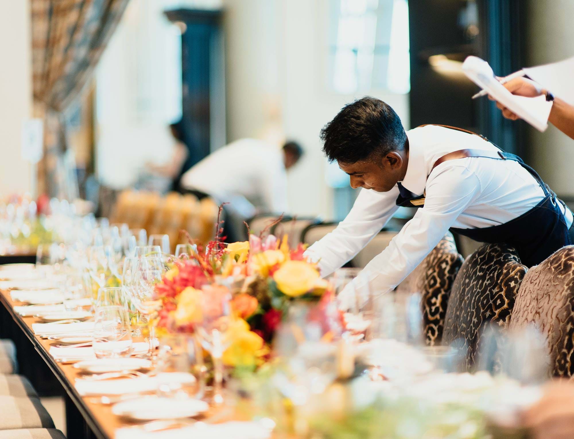 Waiters laying a long grand table