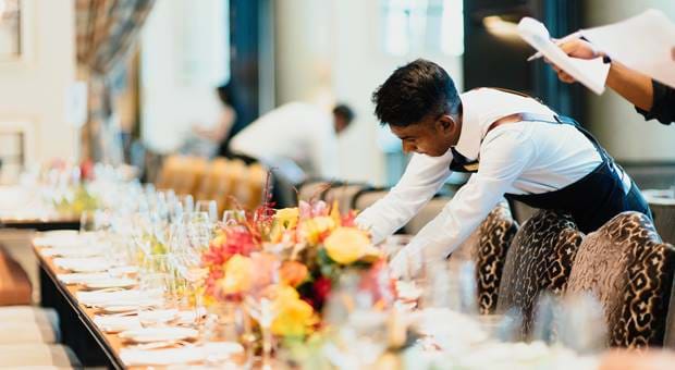 Waiters laying a long grand table