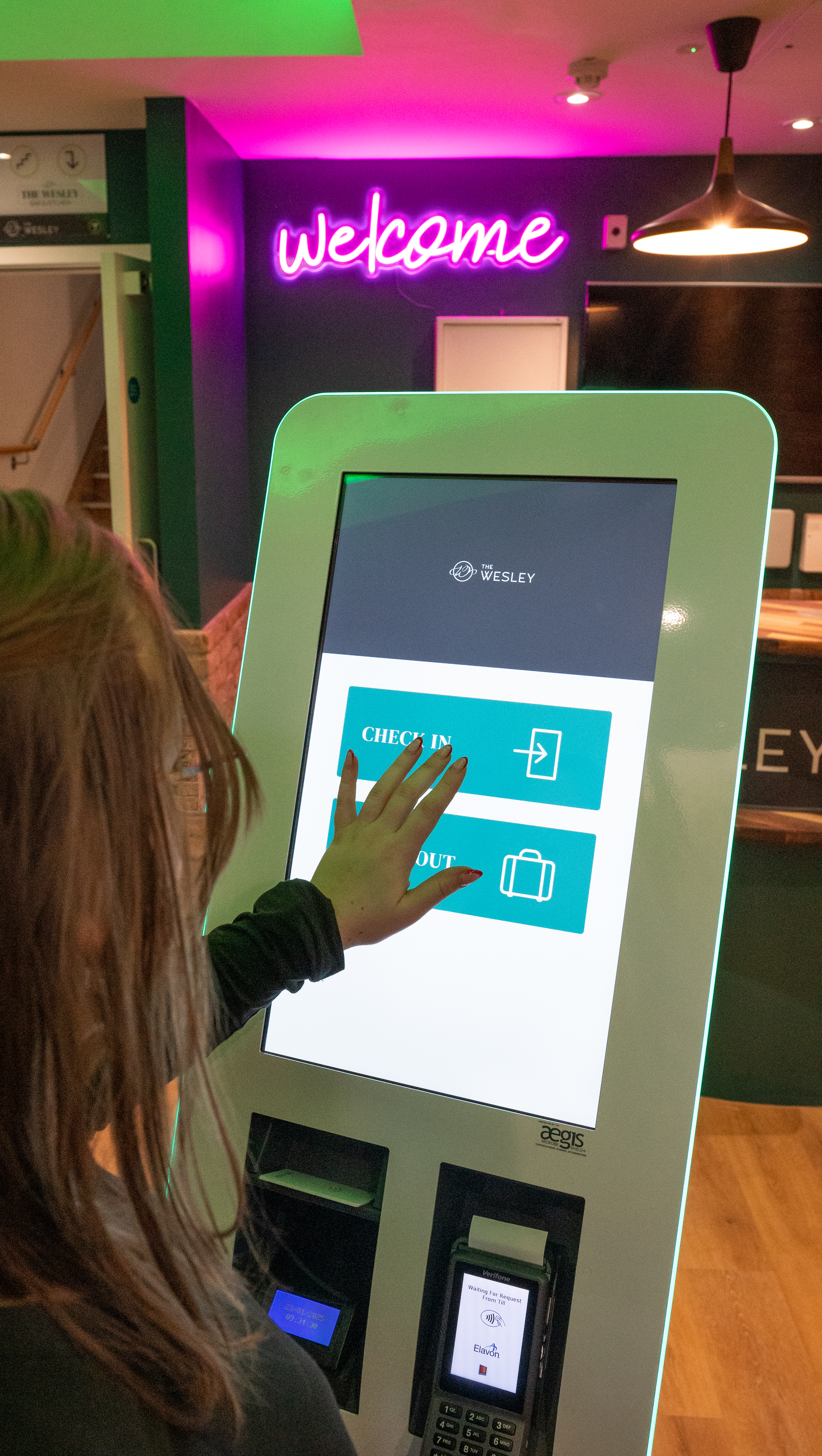 Someone using a check in machine at The Welsey