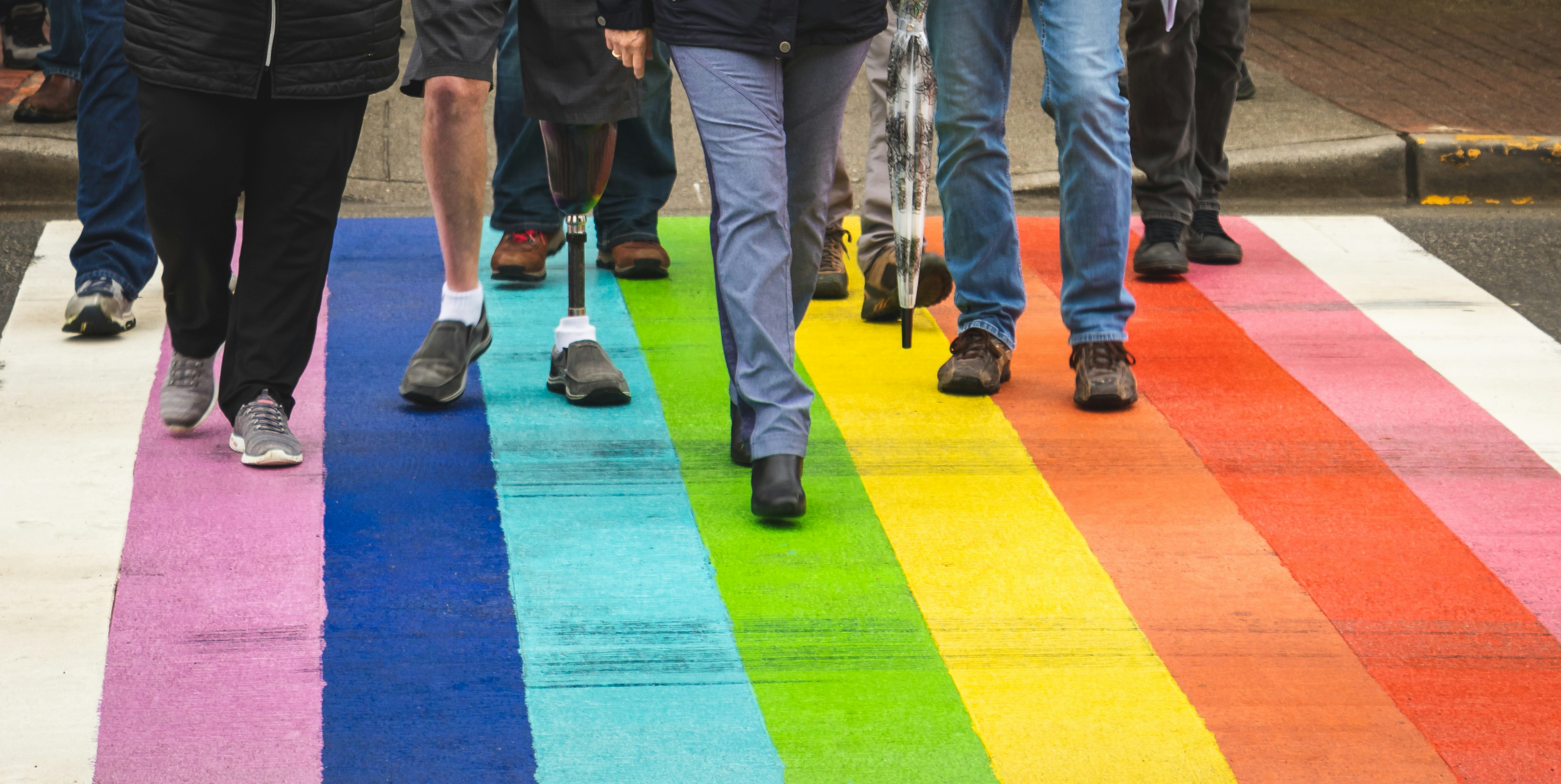 People walking over a rainbow flag