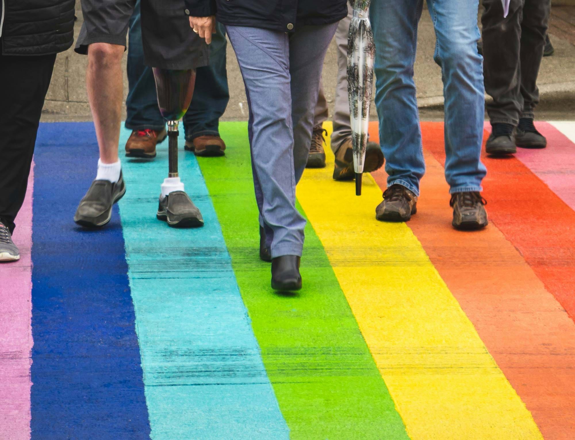 People walking over a rainbow flag